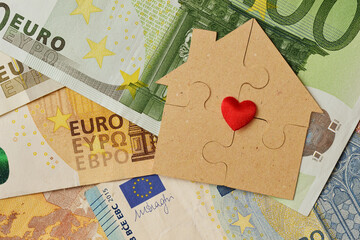 Puzzle house made of recycled paper on euro banknotes - Concept of house, building bonus and ecology