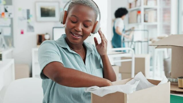 Black woman, music headphones and dance in logistics office, ecommerce shipping company or creative e commerce startup. Smile, happy and excited retail worker with dropshipping product delivery boxes