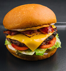 Bacon burger with beef patty on black tray