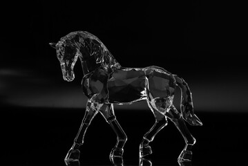 Crystal horse on black background. Low key.
