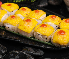 sushi with cheddar cheese on black plate top with yellow curry