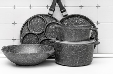 Set of kitchen cast aluminum pans on kitchen counter.