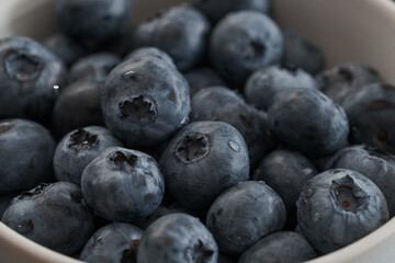 Fresh washed blueberries in white bowl closeup