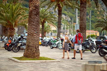 A young couple is walking the riviera during a holiday on the seaside. Vacation, relationship, seaside