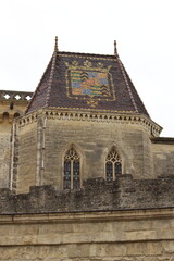 Fototapeta na wymiar Mediaeval roof tiling, Château de Duché, Uzes, France. Glazed tile roof, Duke's chateau, Uzes. Seen on an overcast winter day. Moody medieval castle shot