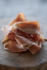 Thin slices of jamon on olive wood board