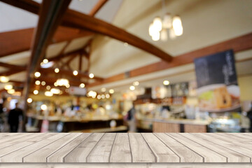 Floor of an empty wooden table with a backdrop of restaurant bokeh.