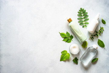 Natural cosmetic concept. Skin care product, cream, soap, tonic, mask with green plants. Flat lay image with copy space.
