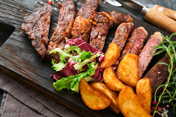 Steaks. Sliced grilled meat steak New York, Ribeye or Chuck roll with with garnished with salad and...