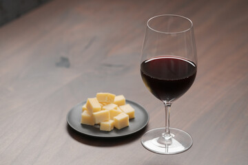 glass of red wine with vintage cheese on small plate