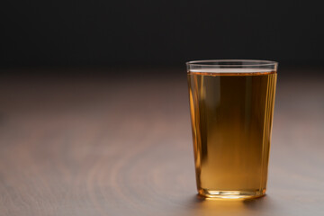 Organic apple cider in tumbler glass on wood table