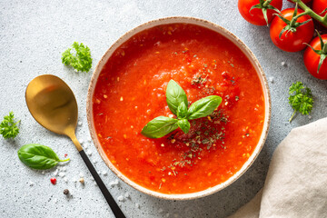 Tomato soup on light stone table. Vegan dish. Top view on light stone table.
