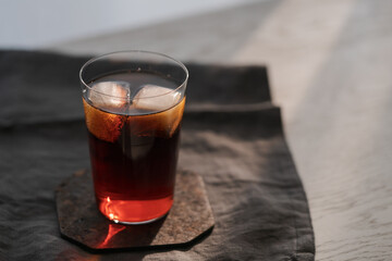 Cola with ice in tumbler glass on wood table with copy space