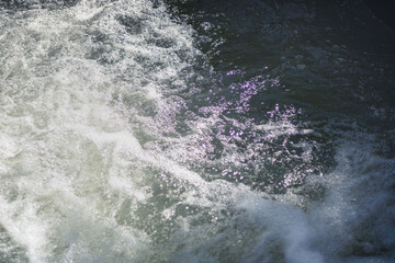 the surface of the water foaming and glaring in the sun
