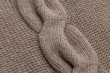 Fototapeta na wymiar Braid pattern on knitted fabric. Hobby and needlework. Close-up.