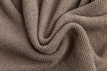 Knitted brown fabric. Hobby and needlework. Close-up. Space for text.