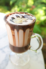 Mouthwatering hot chocolate in a glass garnished with sliced almonds