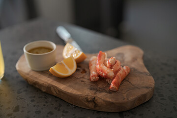 Crab legs with lemon and dressing on olive woob board