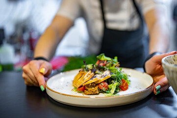 Obraz na płótnie Canvas Chef cooking Caesar salad on restaurant kitchen