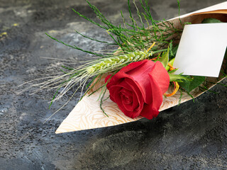 Red rose with an ear of wheat and a gift card, for Valentine's Day or St. George's Day.