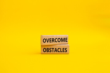 Overcome obstacles symbol. Concept words Overcome obstacles on wooden blocks. Beautiful yellow background. Business and Overcome obstacles concept. Copy space.