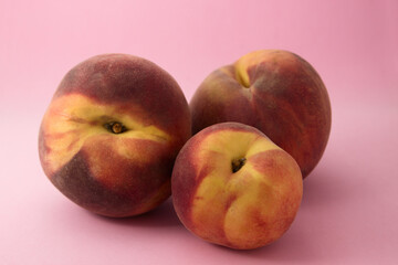 Still life of three ripe peaches isolated on pink background