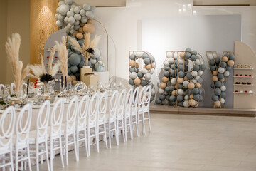 Decorating restaurant banquet room interior elements with colorful helium balloons, big letters...