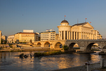 Obraz premium SKOPJE, NORTH MACEDONIA - AUGUST 10, 2019: Stone bridge and the Archaeological Museum of the Republic of Macedonia in Skopje, North Macedonia