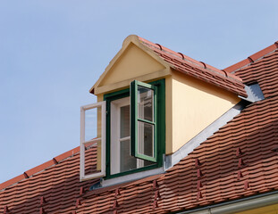View of the open attic window on a rooftop with a clear blue sky in the background, Upper Town,...