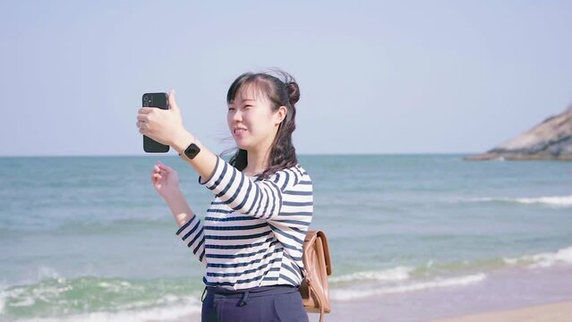 Woman traveling to the beach, taking pictures and videocall