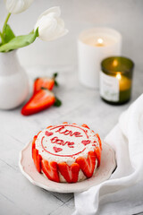 Small bento cake with strawberries. Strawberry cake for birthday or St. Valentine's Day with tulips and candles. Korean cake for one person.
