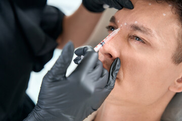 Man in beauty clinic getting face injection