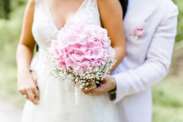 Braut mit rosa Brautstrau&szlig; mit Hortensien und Schleierkraut	