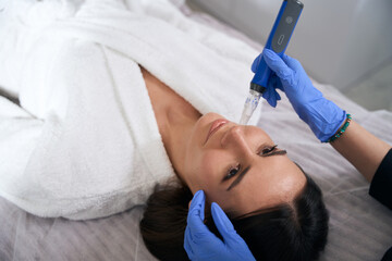 Doctor holding device in microneedle mesotherapy and doing resurfacing procedure