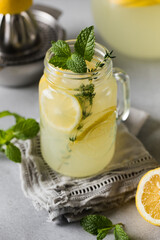 Homemade lemonade with fresh lemon slices and mint leaves in a glass. A summer refreshing drink.