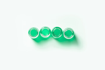 set of flasks, jars for laboratory with green liquid. On a white, light background. View from above.