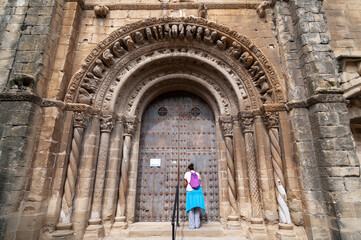 Una turista en la portada románica de la iglesia de Uncastillo en Aragón, España.