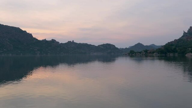 湖に映り込む夕焼け空と巨岩の多いハンピの奇景（リアルタイム・ズームイン）：サナプール湖・ハンピ・インド