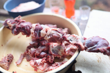Marinated raw meat prepared for barbecue cooking on table
