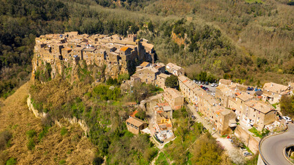 Fototapeta na wymiar Aerial view of old town of Calcata, in the Province of Viterbo, Lazio, Italy. The town overlooking the valley of Treja. All houses have traditional red tiled roofs in the historical centre of Calcata.