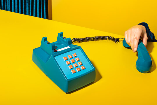 Person picking up phone on yellow background
