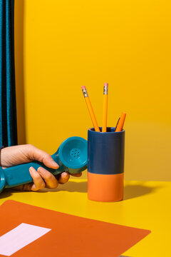 Handset of retro phone off hook on yellow desk