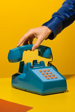 Person hanging up phone on yellow background