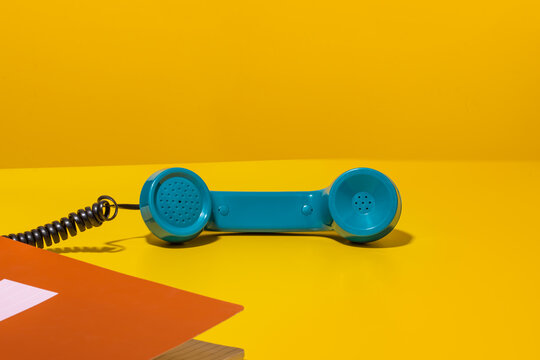 Handset of retro phone off hook on yellow desk