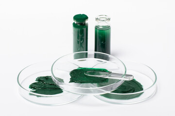Spirulina mask or cream in a Petri dish. Cosmetic spatula. Spirulina powder in a jar. Spirulina oil...