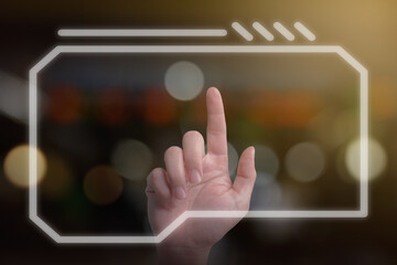 Closeup of man hand using finger to touch and press the button on virtual computer screen with dark bokeh background. Futuristic technology concept.