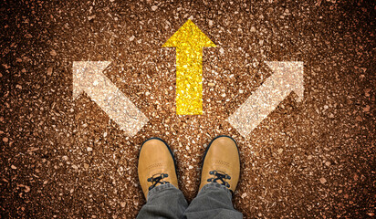 Yellow leather shoes and three chalky arrows on ground - decision concept
