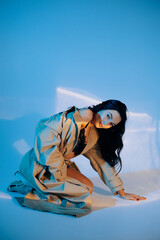 Young sexy woman poses in black lacy lingerie and unbuttoned cloak.