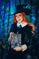 halloween witch young dark pretty woman vintage spell book red hair glasses gothic dress