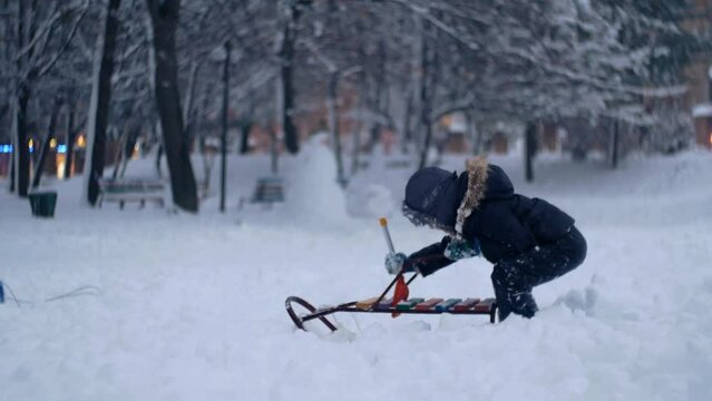  Cute ukrainian kid boy child wearing warm clothes playing in snow in cold winter christmas weather 